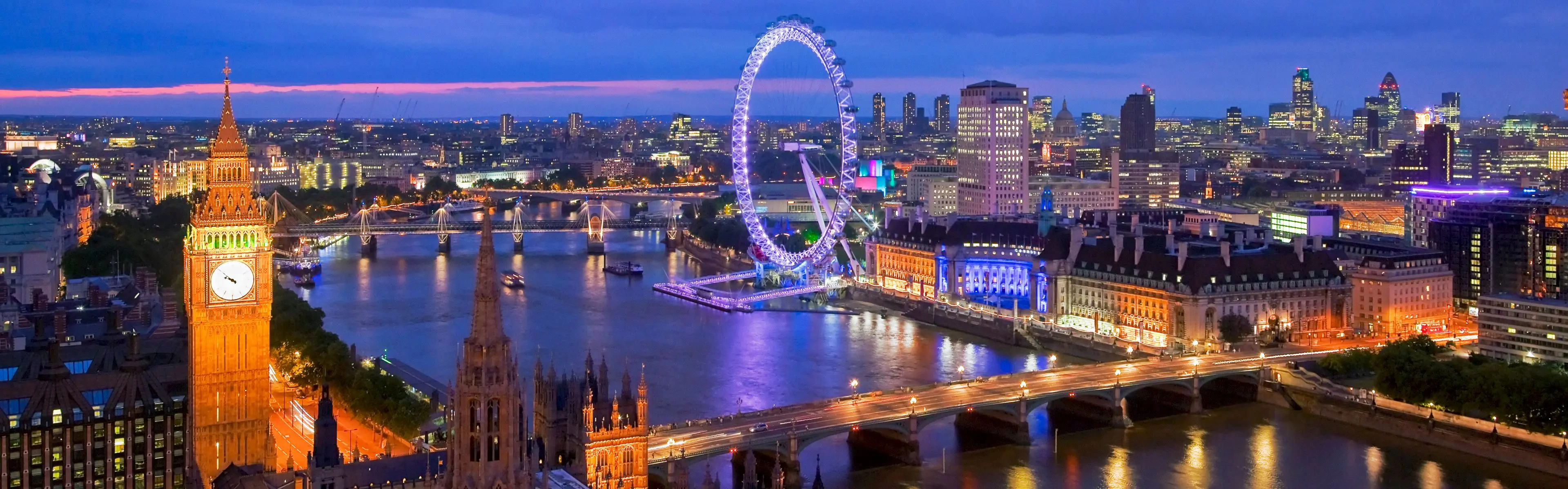 Londres au crépuscule, avec une tour d’horloge illuminée, le London Eye, des ponts et des reflets sur la Tamise.
